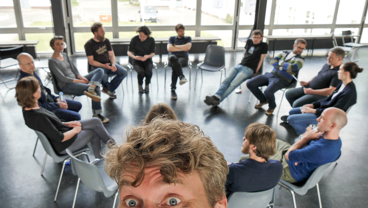 Reinblau-Mitglieder sitzen im Kreis bei einem Teamtreffen im Open-Space-Format.